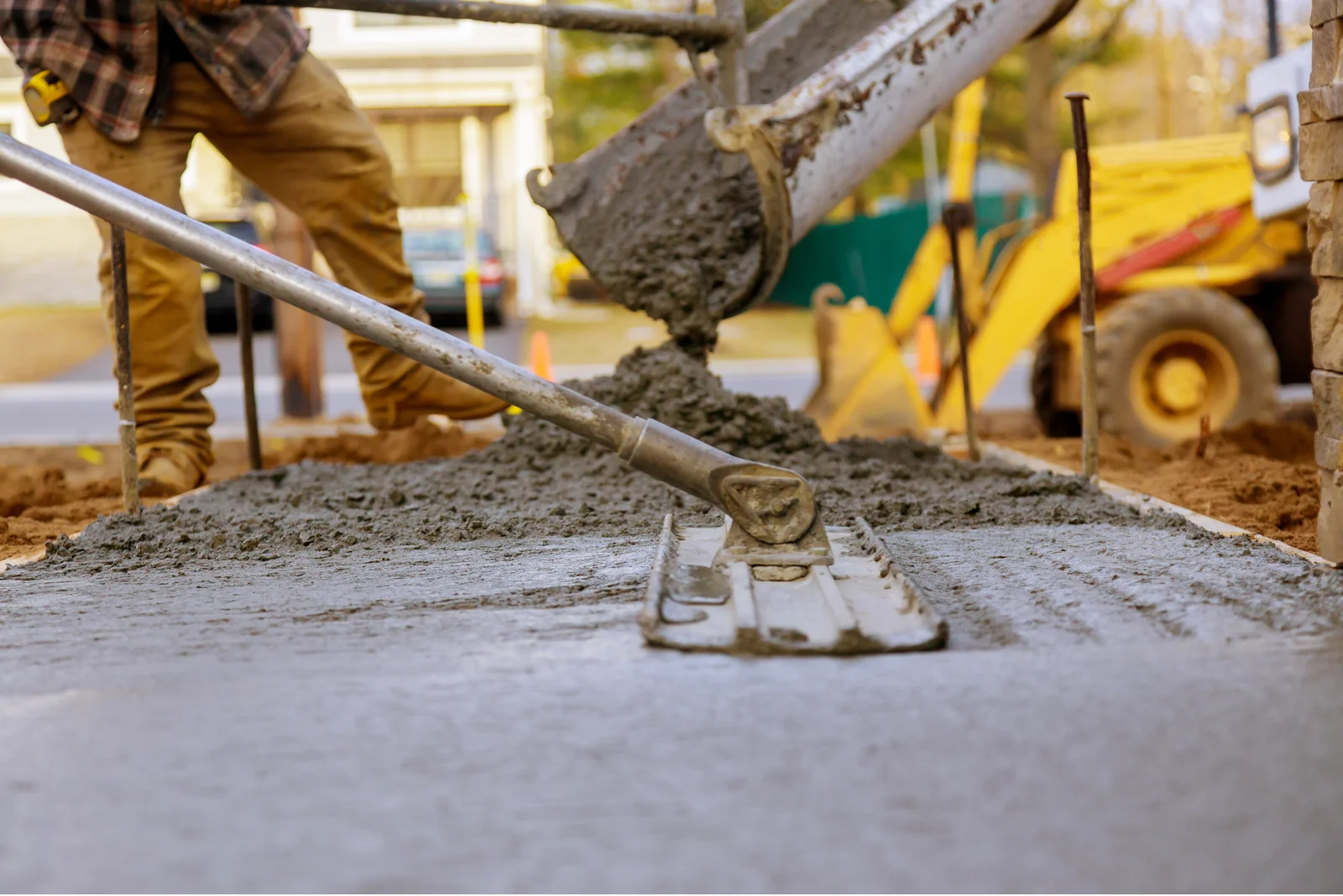 Concreter pouring and screeding fresh concrete on a residential driveway in Canberra ACT