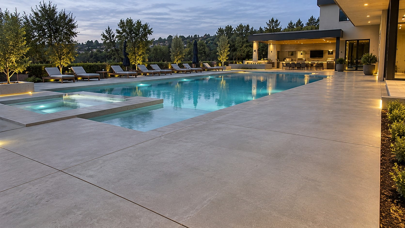 Concrete pool surround around a lit pool and spa in Deakin, ACT